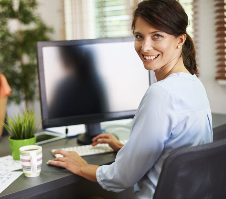 una donna in ufficio davanti al computer felici